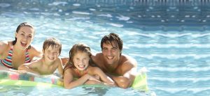 family swimming in a solar heated swimming pool