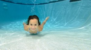 girl swimming under water in a swimming pool